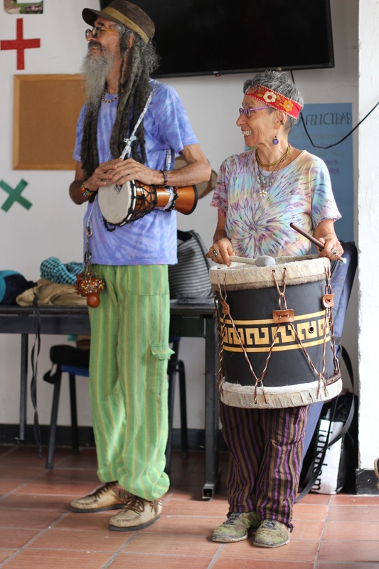 Dos artistas con tambor y guitarra en un salón de clase
