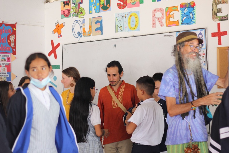 Un tallerista conversa con niños en un salón decorado